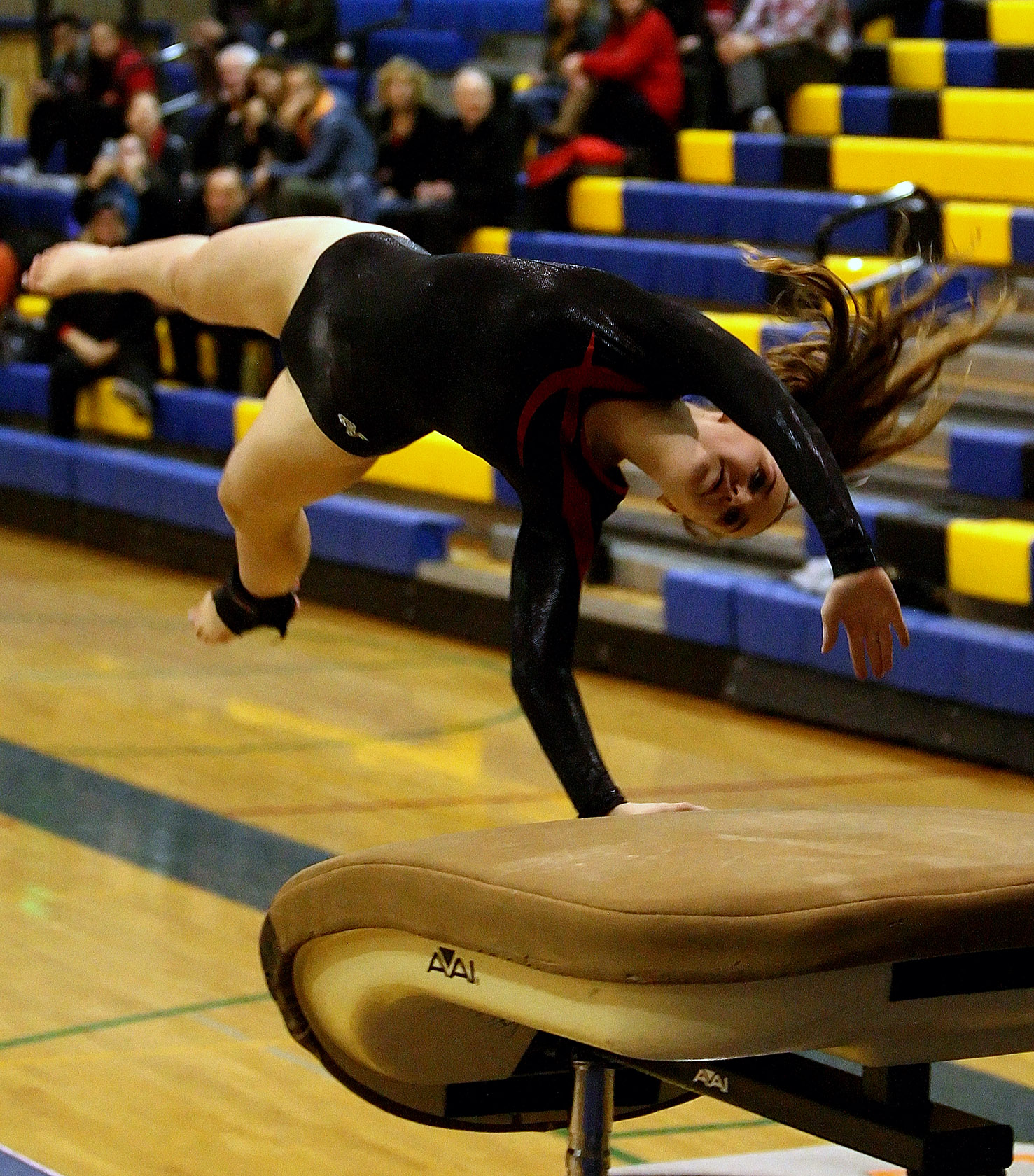 A Ballard gymnast hits the vault.