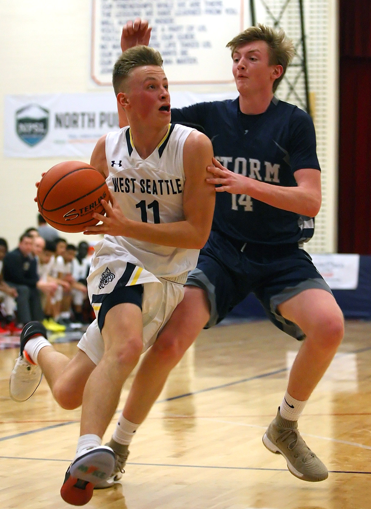 Jackson Golgart of West Seattle drives to the hoop with defensive pressure from Squalicum's Eric Monahan.
