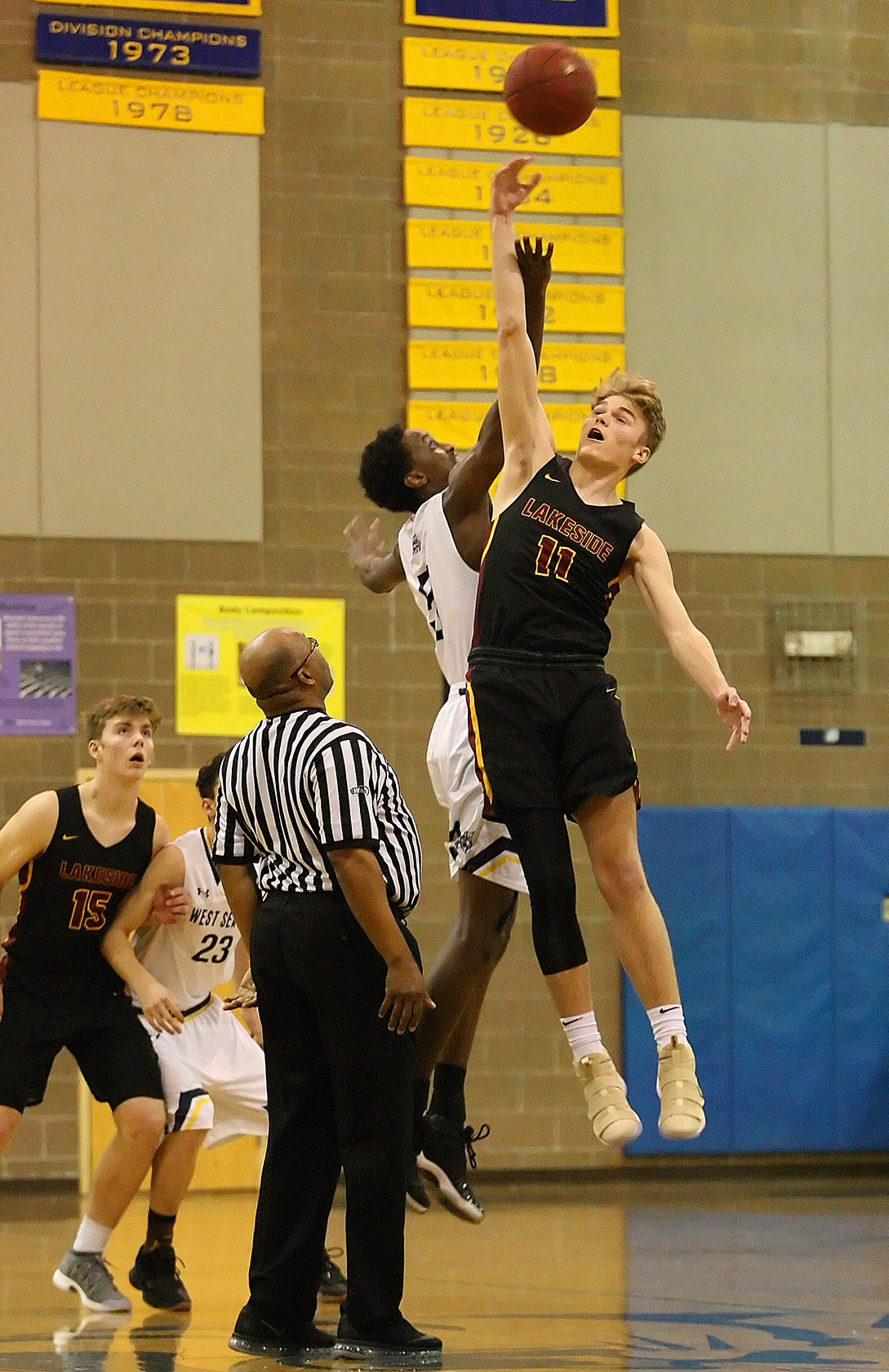 Abdullahi Mohamed of West Seattle jumps against Lakeside's Max Knight on the opening tip.