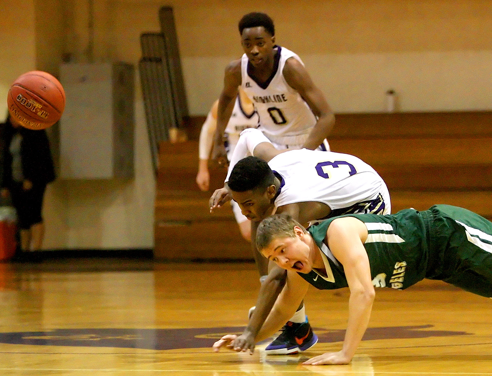 Easton Joslin of Port Angeles fall to the floor going for the ball against Highlines Sam Assefa.