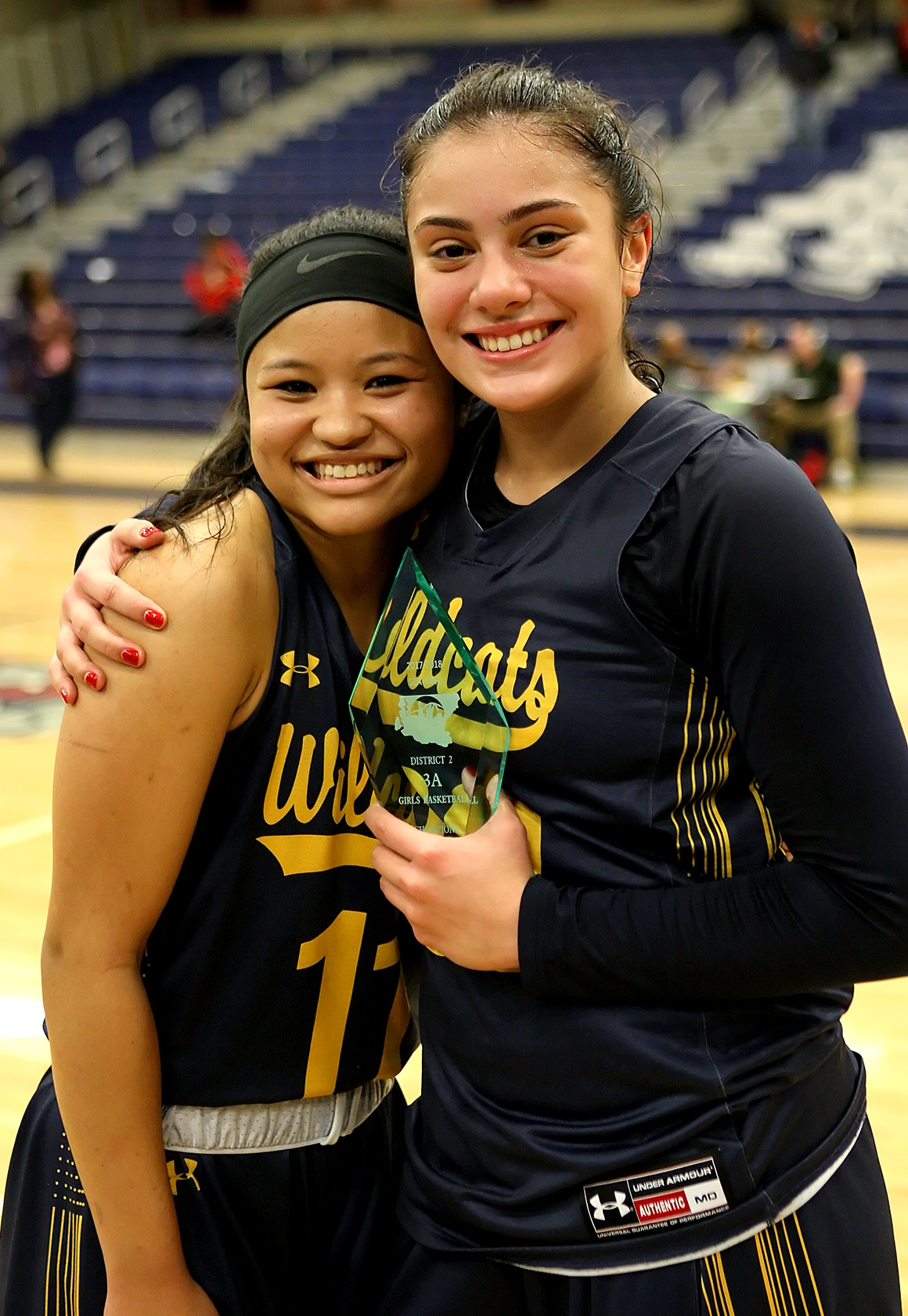 West Seattle's Jasmine Gayles and Meghan Fiso are all smiles as they pose for a photo with the district champion trophy.