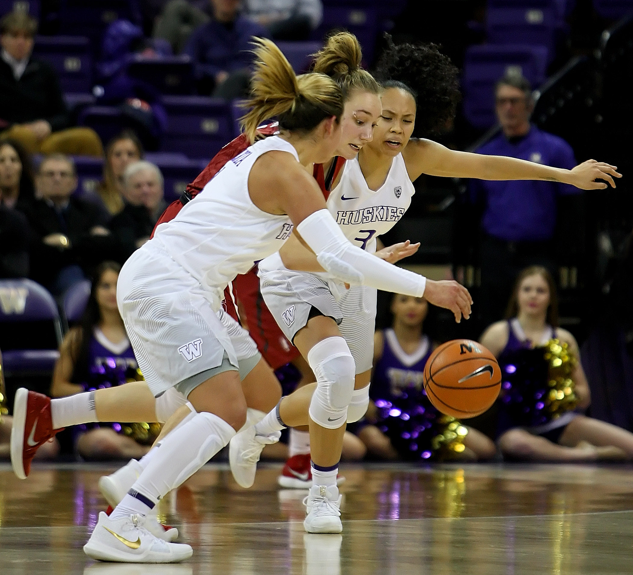 Alanna Smith of Stanford dribbles the ball between Washington’s Amber Melgoza and Mia-Loni Henson.