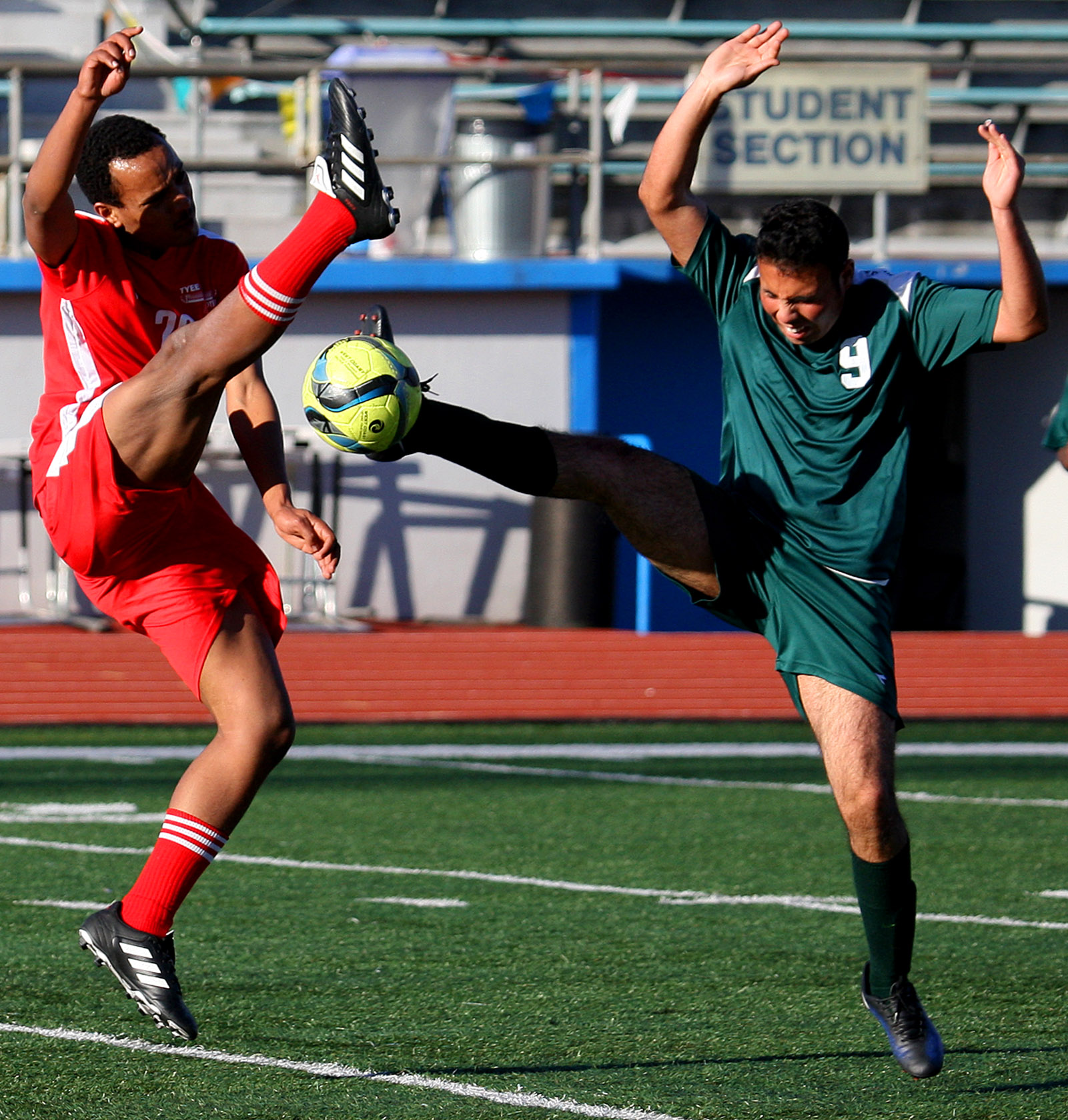 Abubekir Lenty of Tyee and Evergreen's Adair Ramirez reach for the ball with their feet.