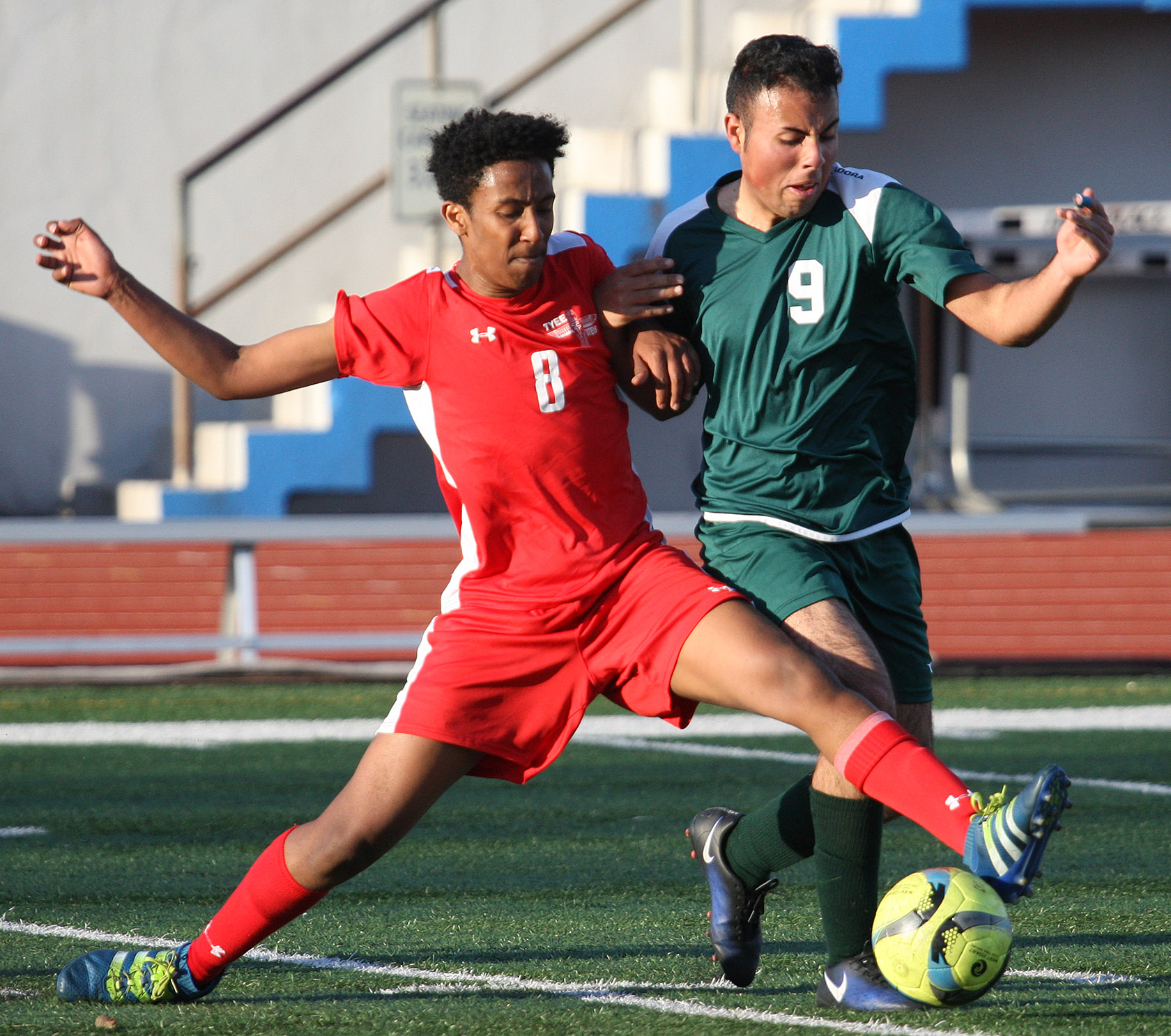 Ali Yusuf of Tyee and Evergreen's Adair Ramirez of Evergreen try to gain control of the ball.