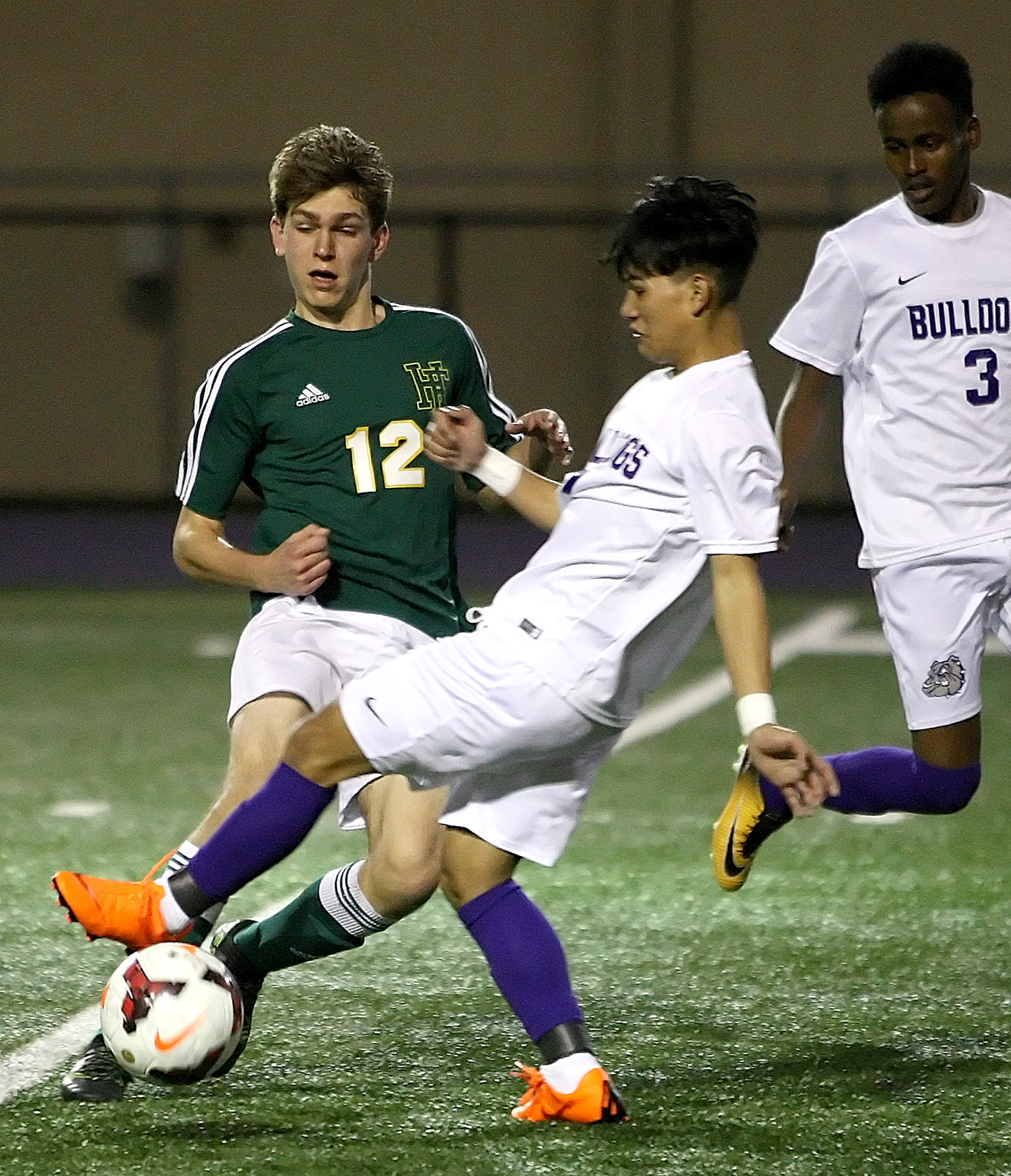 Peter McKown of Foss and Foster's Bik Piang go for the ball.