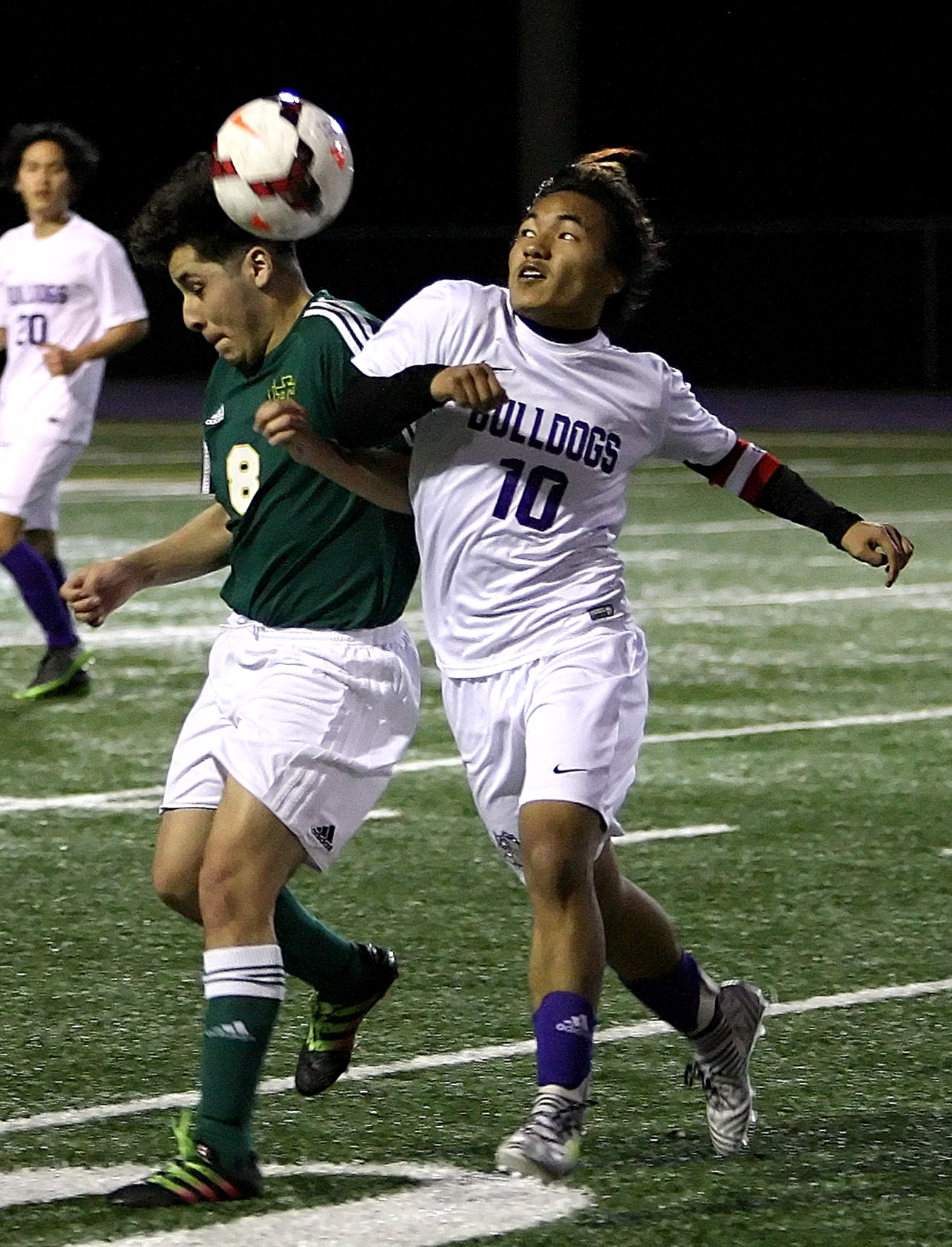 James Mung of Foster keeps his eye on the ball as he bumps into Foss 's Moses Ramos.