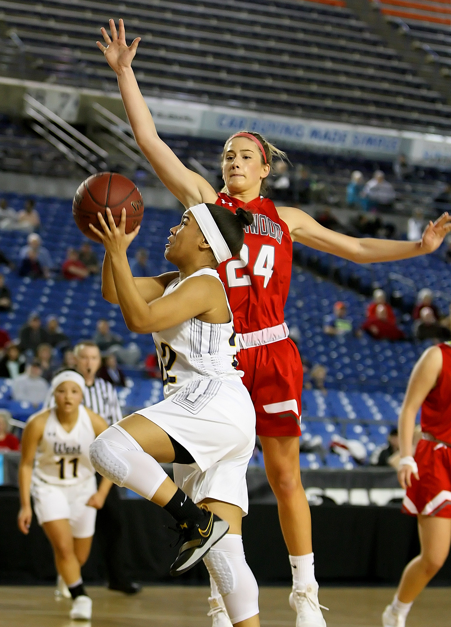 Jayla Wilson of West Seattle scores on a layup against Stanwood's Jullian Heichel.