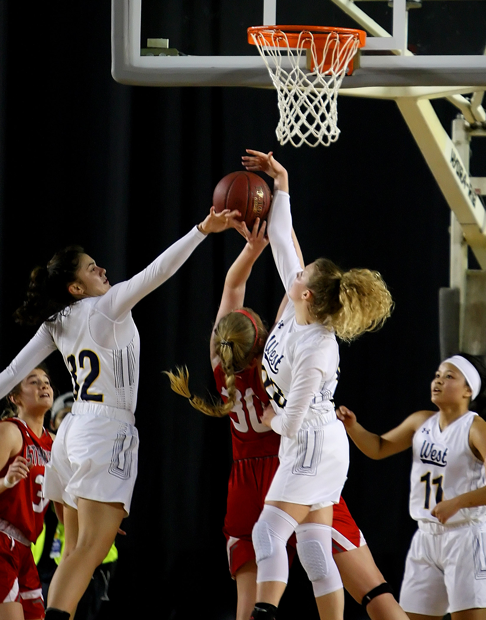 Megan Fiso and Grace Sarver of West Seattle block a shot attempt by Stanwood's Kaitlin Larson.