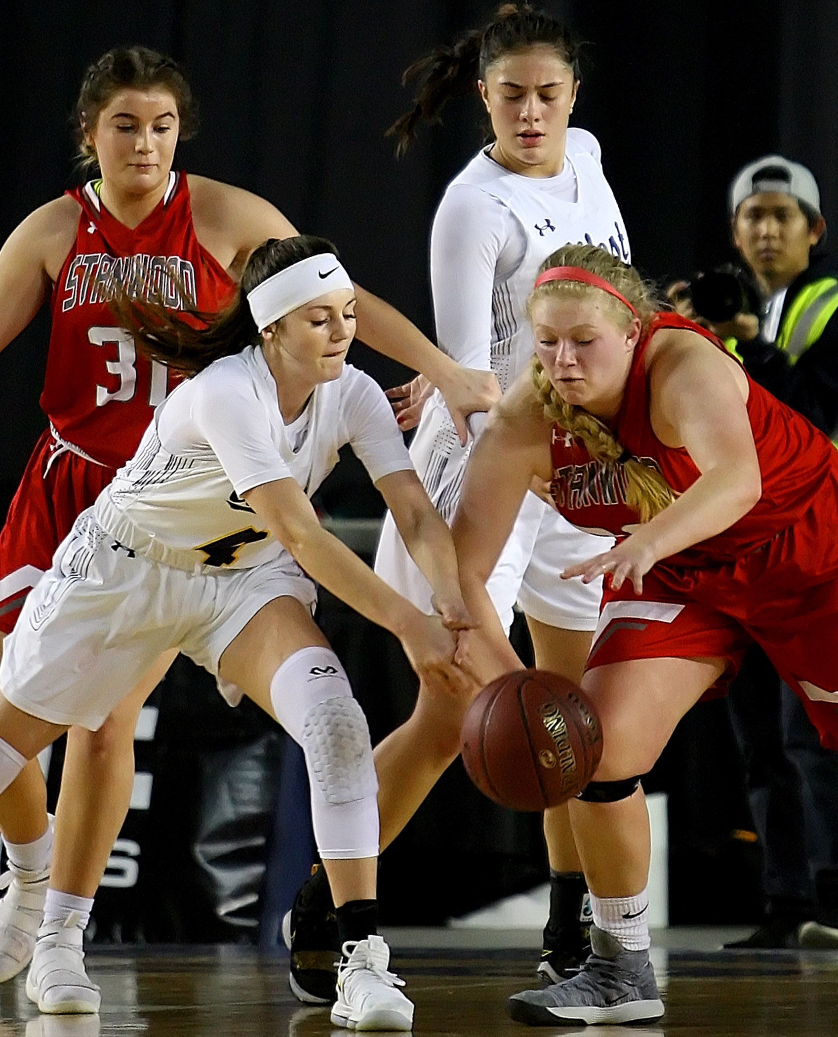 Kelsey Lenzie of West Seattle and Stanwood's Kaitlin Larson go after a loose ball.