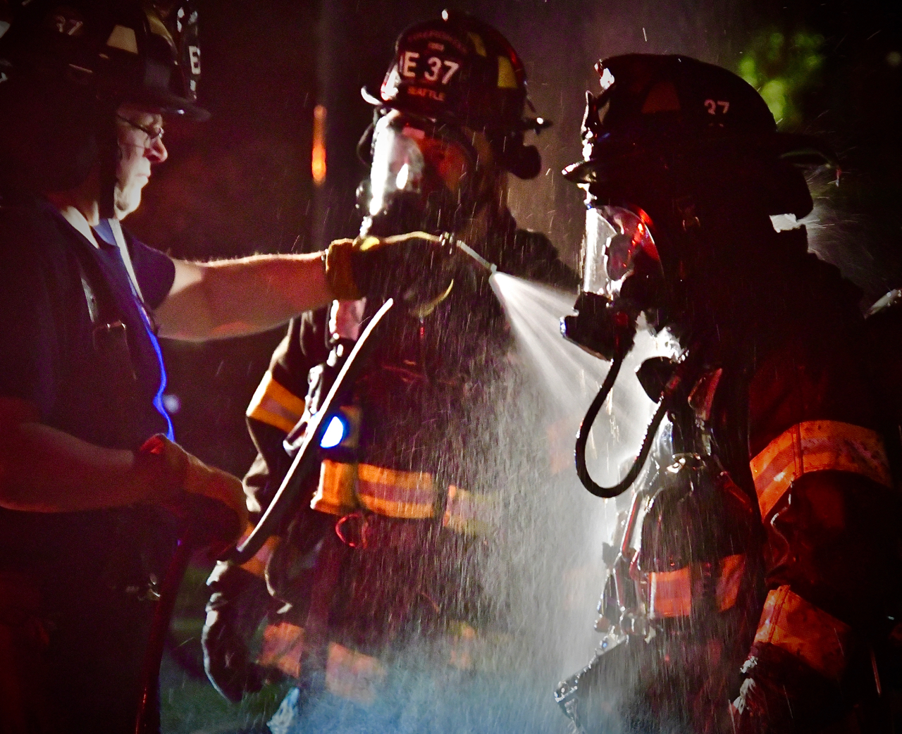 A firefighter gets the smoke and ash hosed off. Photo by Patrick Robinson
