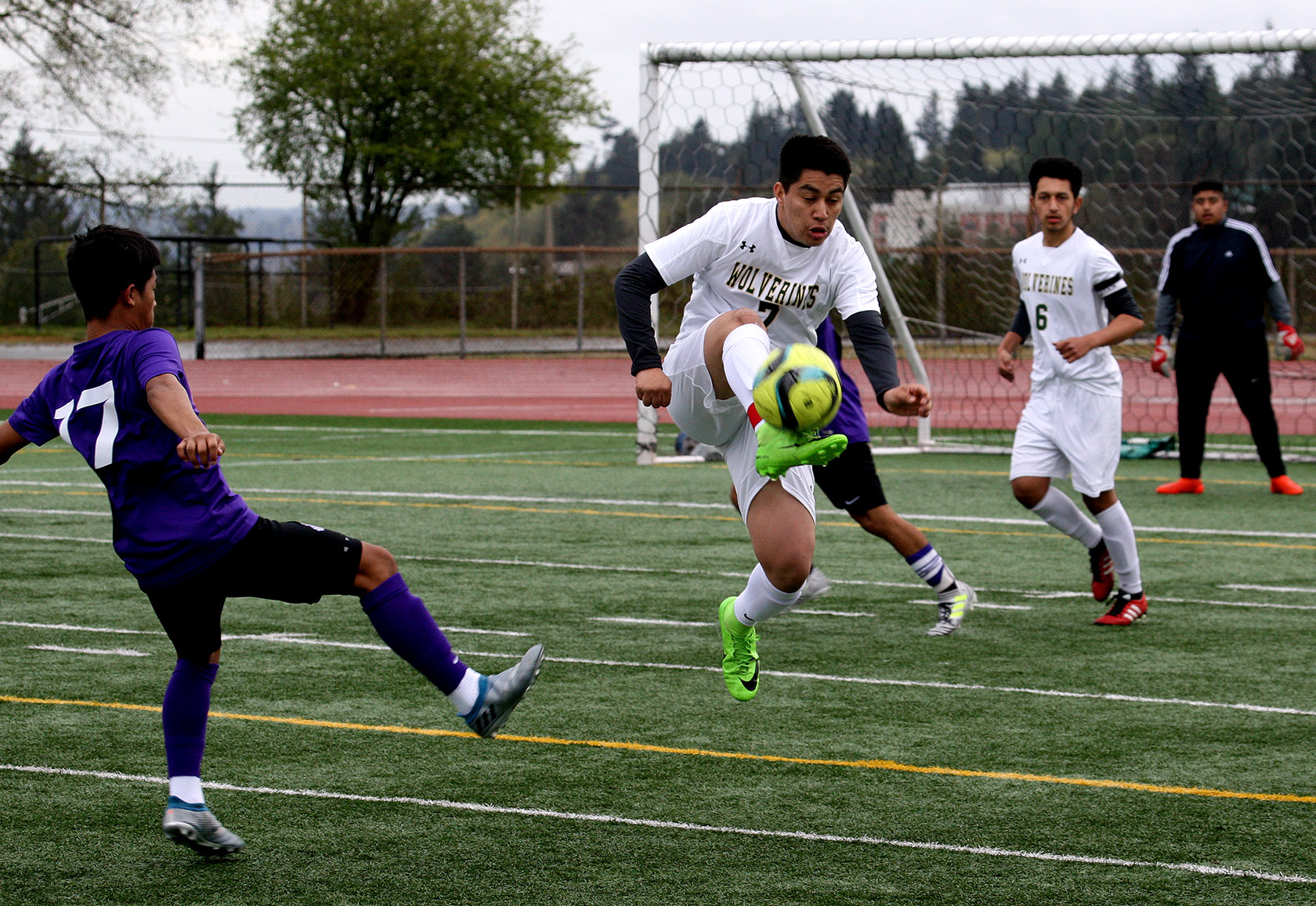 Josue Pedroza of Evergreen does a jump kick to get the ball away from the goal.