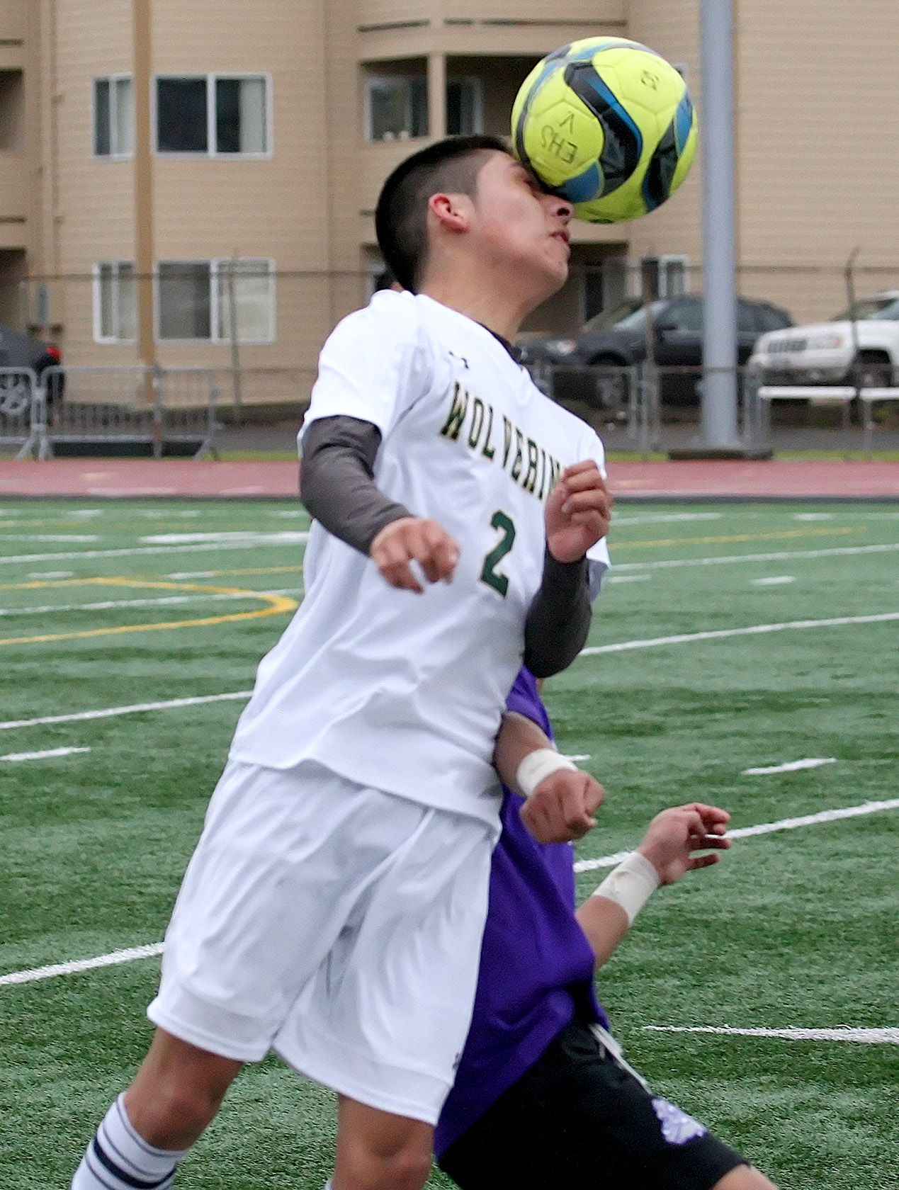 Deker Vasquez of Evergreen heads the ball over the back of a Foster's Bik Ceu.