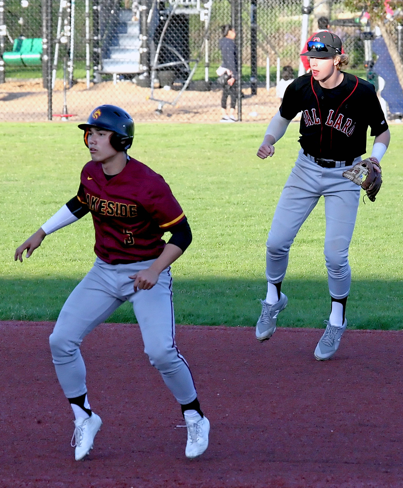 Lakeside base runner Jake Korman and Ballard's shortstop Mason Hoover are caught airborne during a pitch. 