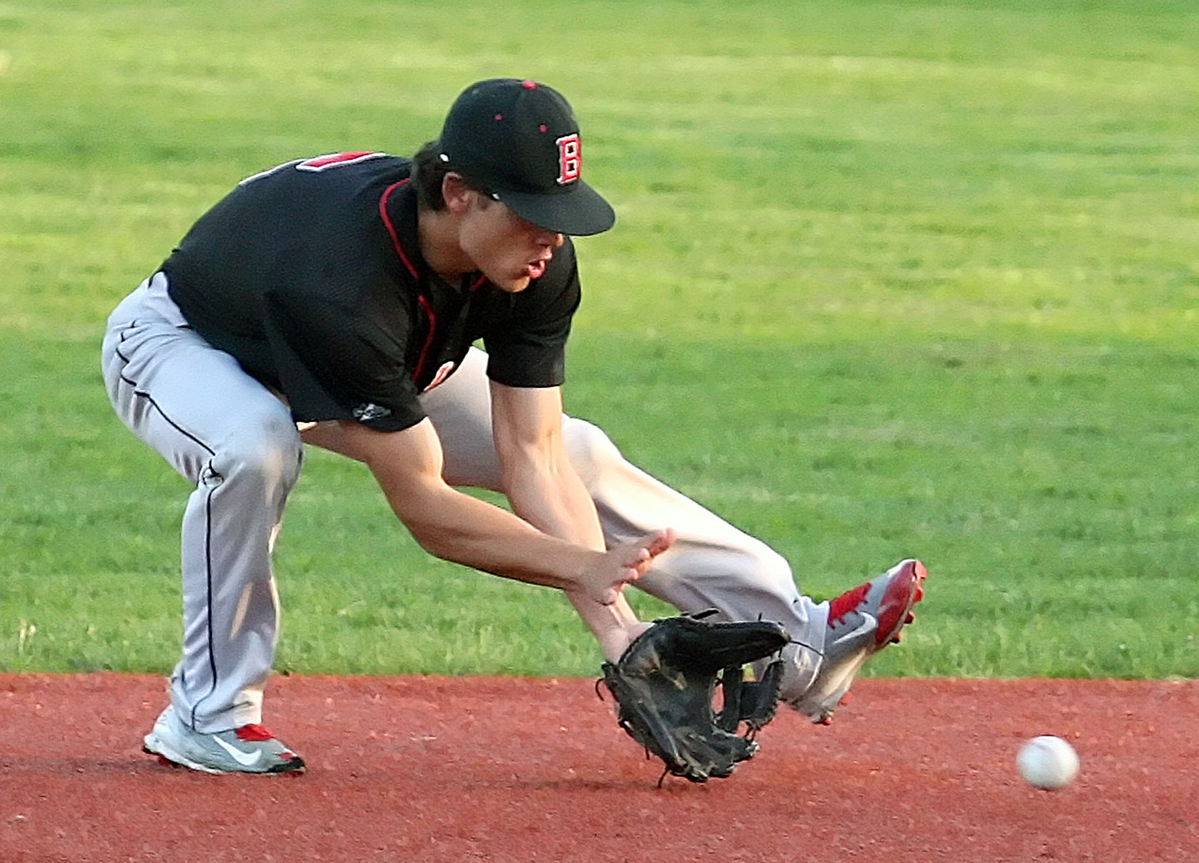 Ethan Doshi of Ballard fields the ball to get the out at first.