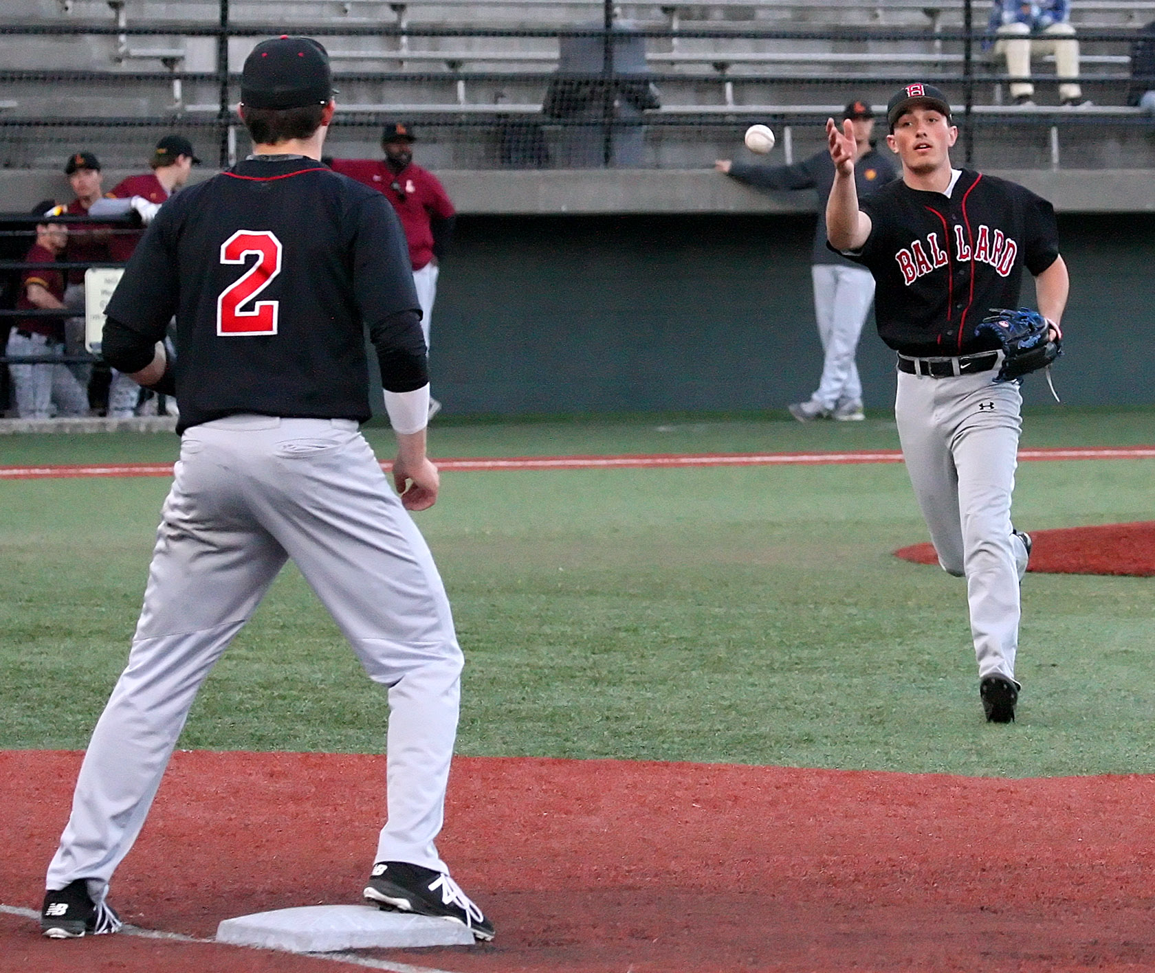 Pitcher Jay Dunbar of Ballard under hands the ball to first baseman Lukas Seeley for an easy out.