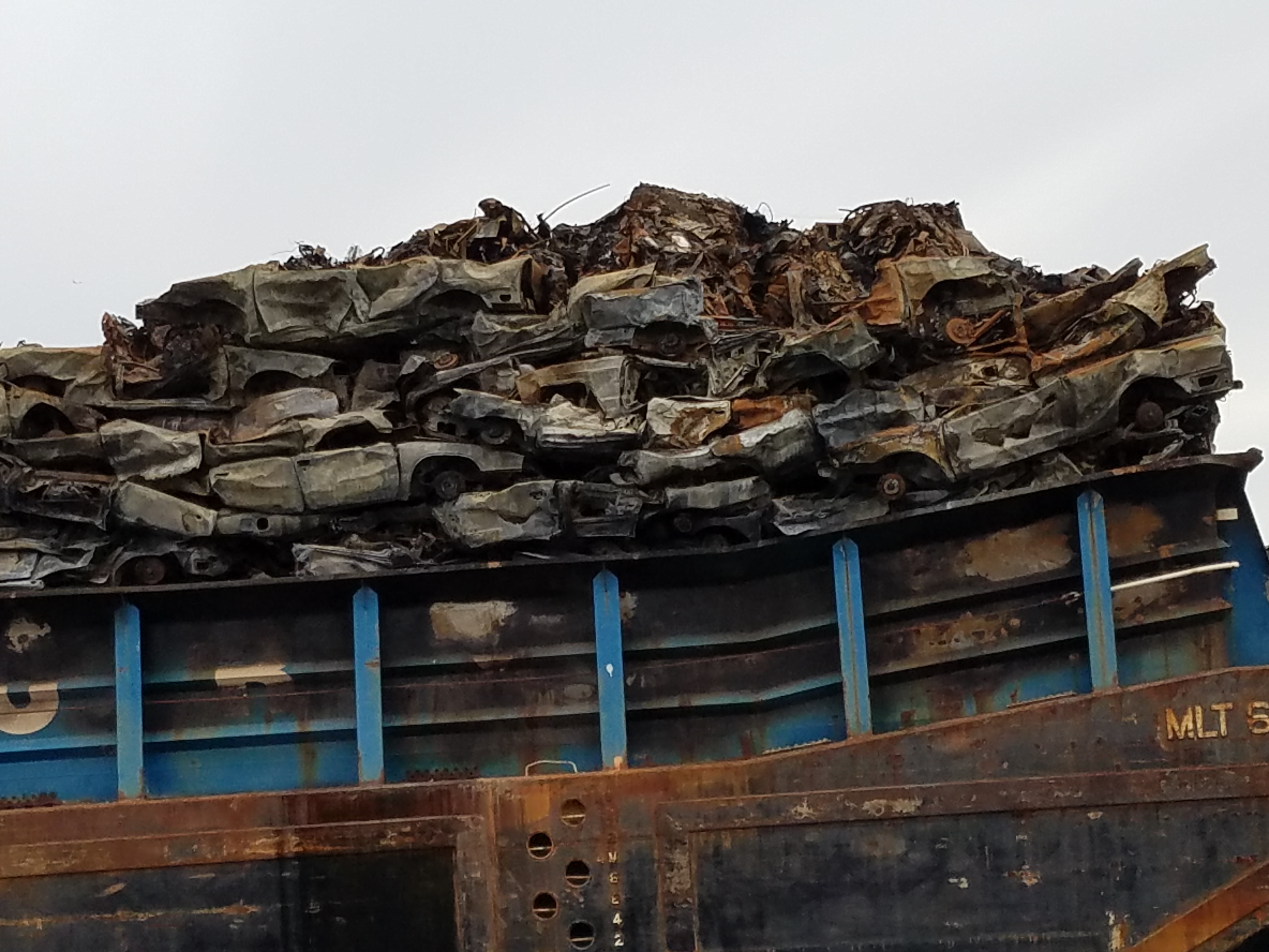 crushed cars on barge.