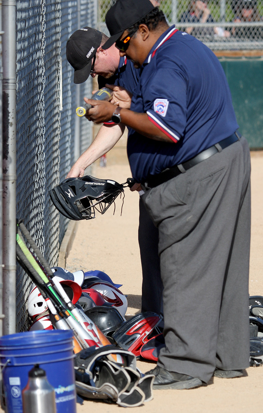 Little League umpires do their traditional pre-game equipment inspection before the game.