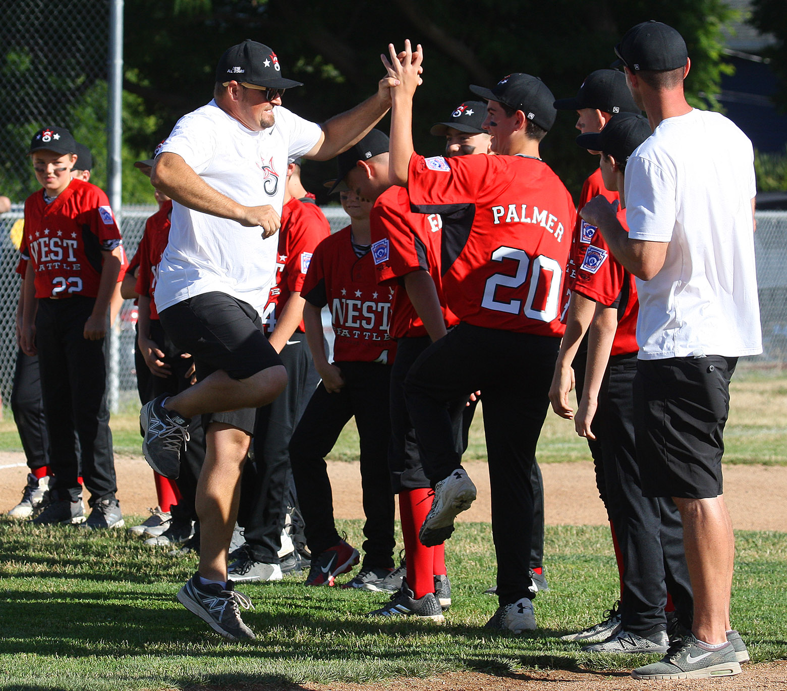 During team introductions a West Seattle coach gets in a high five and leaps for joy.