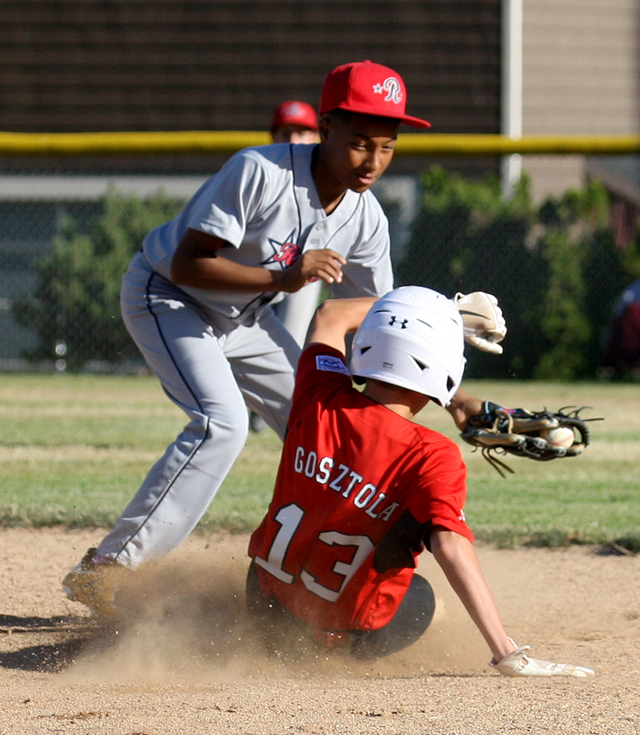 Miles Gosztola of West Seattle is safe sliding into second base as Renton's Marcus McCarthy attempts to tag him out.