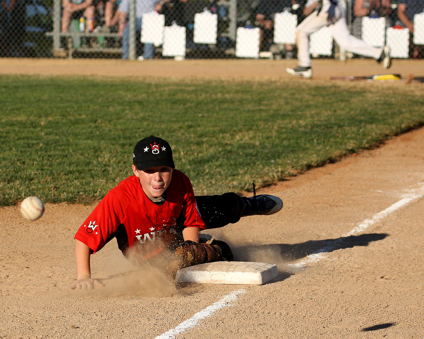 Third baseman Bobby Trigg of West Seattle can only watch as the ball gets by him and heads into left field.