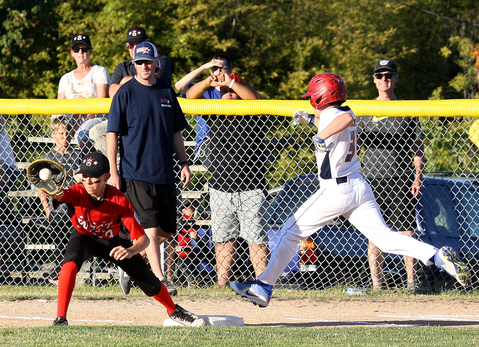 First baseman Miles Gosztola of West Seattle catches the ball as South Highline Nationals Avery Procter is only inches short of the bag.