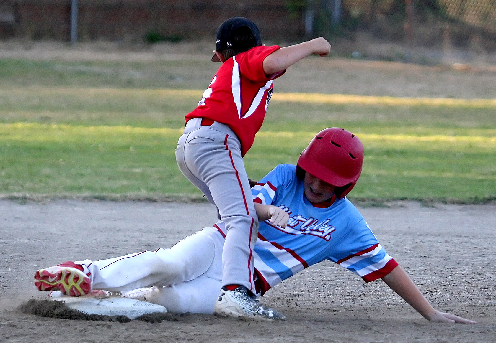 Arthur Knight of West Valley slides safely into second between the legs of West Seattle's Jesse LaBella.