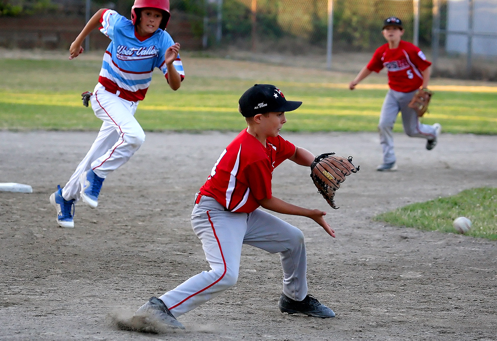 Cody Buehring of West Seattle waits to field the ball as West Valley's Landed Birley heads to third.