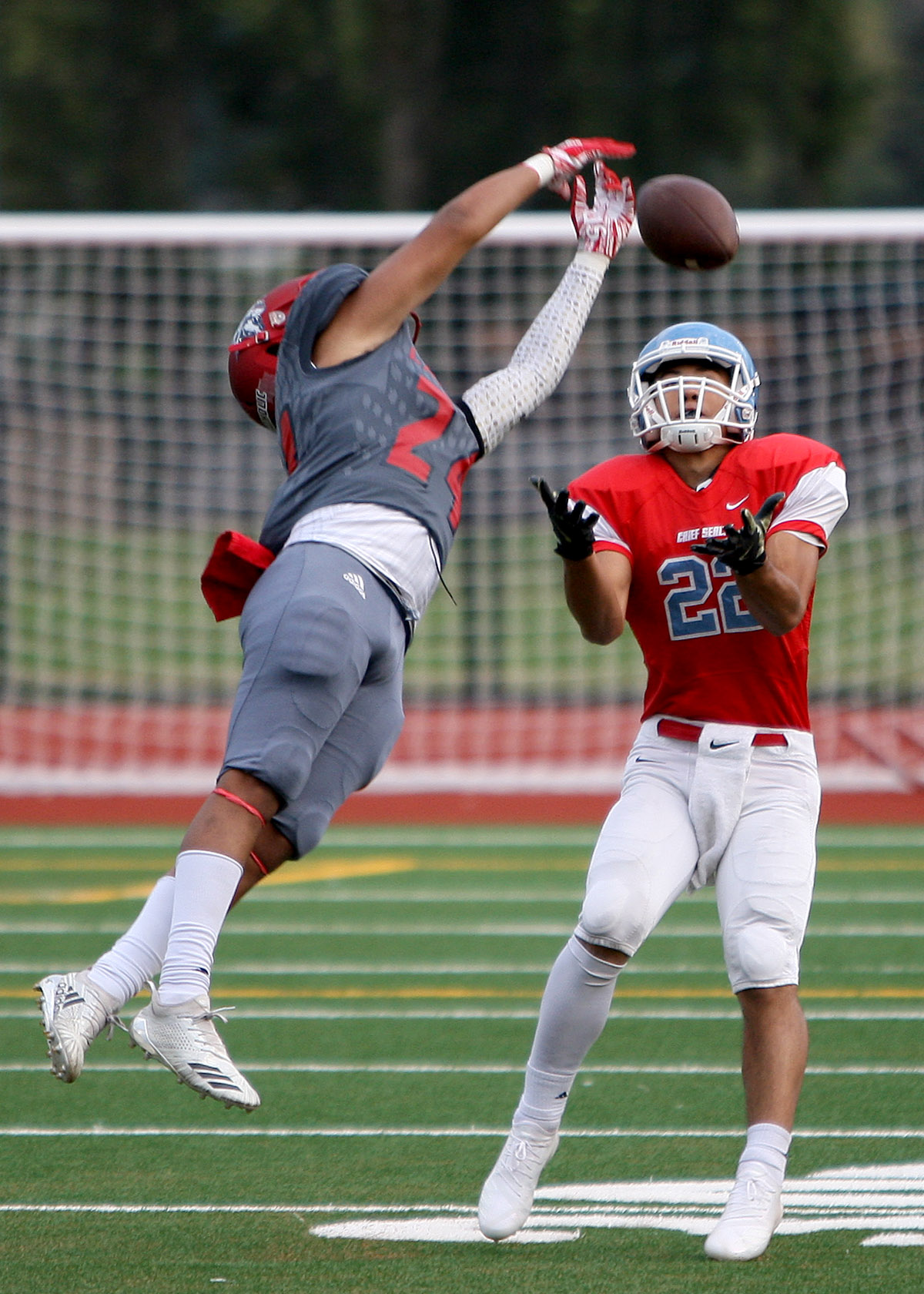 As Jesse Brown of Chief Sealth waits for the ball on a pass Kennedy's Davis Dengah knocks the ball away.