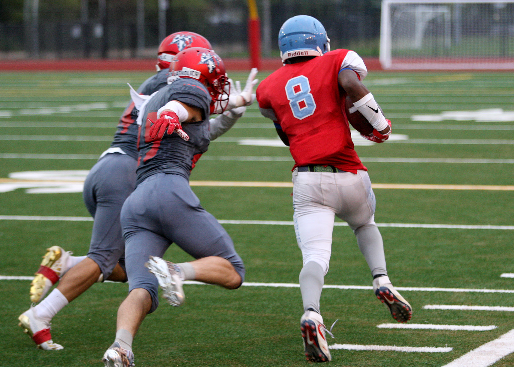 Dontea McMillan of Chief Sealth heads up the sideline against defensive pursuit by Kennedy's Shane Aleaga and Garret Kollar.