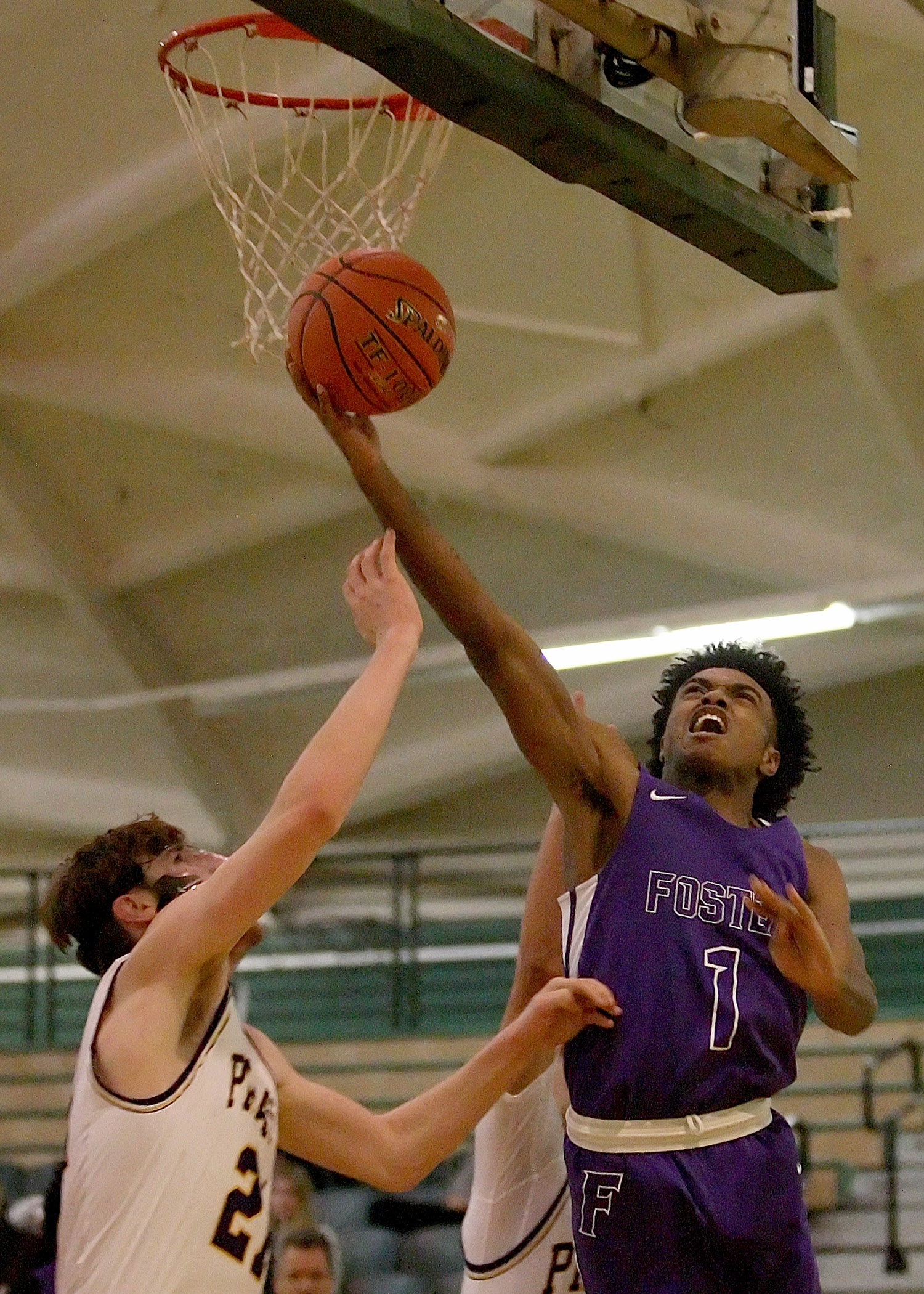  Isaiah Ford of Foster makes a reverse layup against the defensive pressure from Highline's Riley Piper.