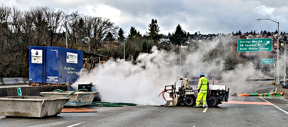 Crews using high-powered water streams to create access points in the bridge.