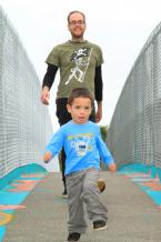 Mark Sandys and son Lucas are the first pedestrians to cross the newely dedicated Little Bridge.JPG